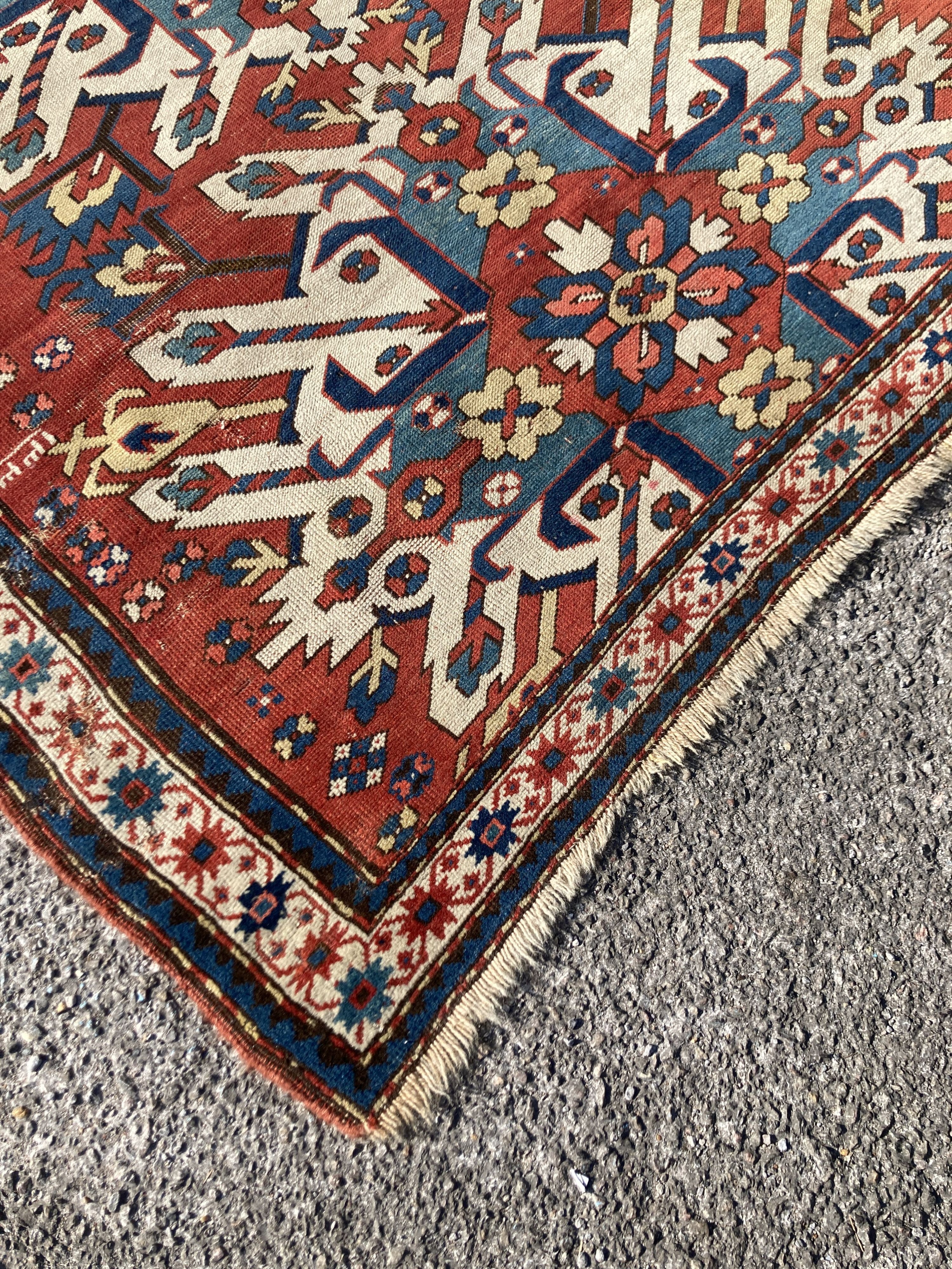 An early 20th century Caucasian “Eagle” Kazak brick red ground rug with triple medallion (altered) 230 x 134 cms.